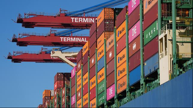 Bild: picture alliance/dpa | Marcus Brandt Ein Containerschiff wird am Containerterminal Burchardkai (CTB) im Hamburger Hafen abgefertigt. US-Präsident Donald Trump hat ein gewaltiges Zollpaket verkündet, das auch die Europäische Union hart trifft. Die US-Regierung führt neue pauschale Zölle in Höhe von zehn Prozent auf die meisten Importe in die Vereinigten Staaten ein.