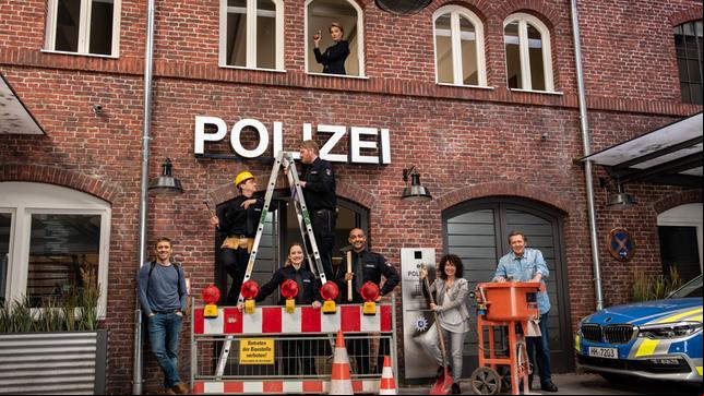Bild: ARD/Thorsten Jander Die Bauarbeiten sind beendet! Das Team vom Großstadtrevier vor dem neuen Revier: v.l.n.r. Piet Wellbrook (Peter Fieseler), Daniel Schirmer (Sven Fricke), Nina Sieveking (Wanda Perdelwitz), Hannes Krabbe (Marc Zwinz), Lukas Petersen (Patrick Abozen), Harry Möller (Maria Ketikidou) und Dirk Matthies (Jan Fedder). Kommissariatsleiterin Frau Küppers (Saskia Fischer, oben) hat alles im Blick.