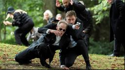 Die Trauerfeier endet in einer Schießerei, bei der Piet Wellbrook (Peter Fieseler, rechts) dem ehemaligen Bandenmitglied Willy Schokow (Mike Darlinger ) das Leben rettet.