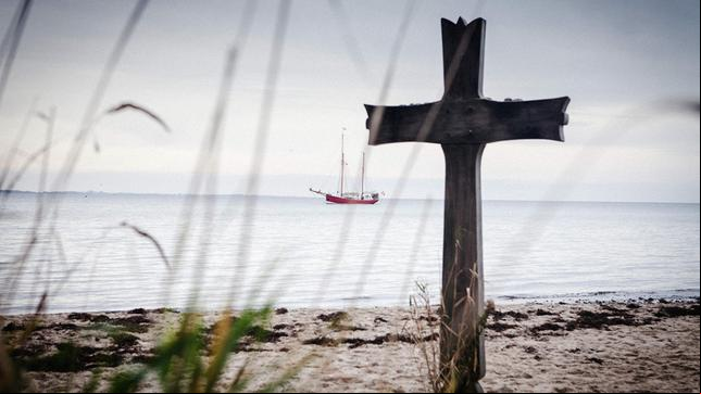 Bild: NDR/Felix Althaus Ein Kreuz am Strand. Im Hintergrund ist das Schiff zu sehen.