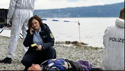 Julia Demmler (Wendy Güntensperger) informiert Nele vom Tatort über Alinas Leichenfund (mit Komparsen).