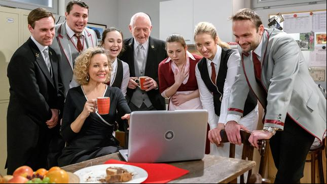 Bild: ARD/Christof Arnold Alfons (Sepp Schauer) wird von Natascha (Melanie Wiegmann), Romy (Désirée von Delft) und dem Rest der Belegschaft (Komparsen) als Held gefeiert.