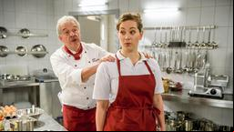 André (Joachim Lätsch) macht Tina (Christin Balogh) klar, dass sie ihre Aufgaben für die Berufsschule nicht während ihrer Arbeitszeit erledigen darf.