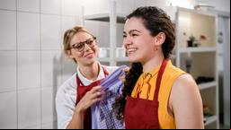 Shirin (Merve Cakir) hilft Josie (Lena Conzendorf) in der Küche.